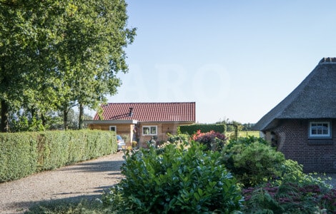 Lange oprijlaan met mantelzorgwoning in de achtertuin